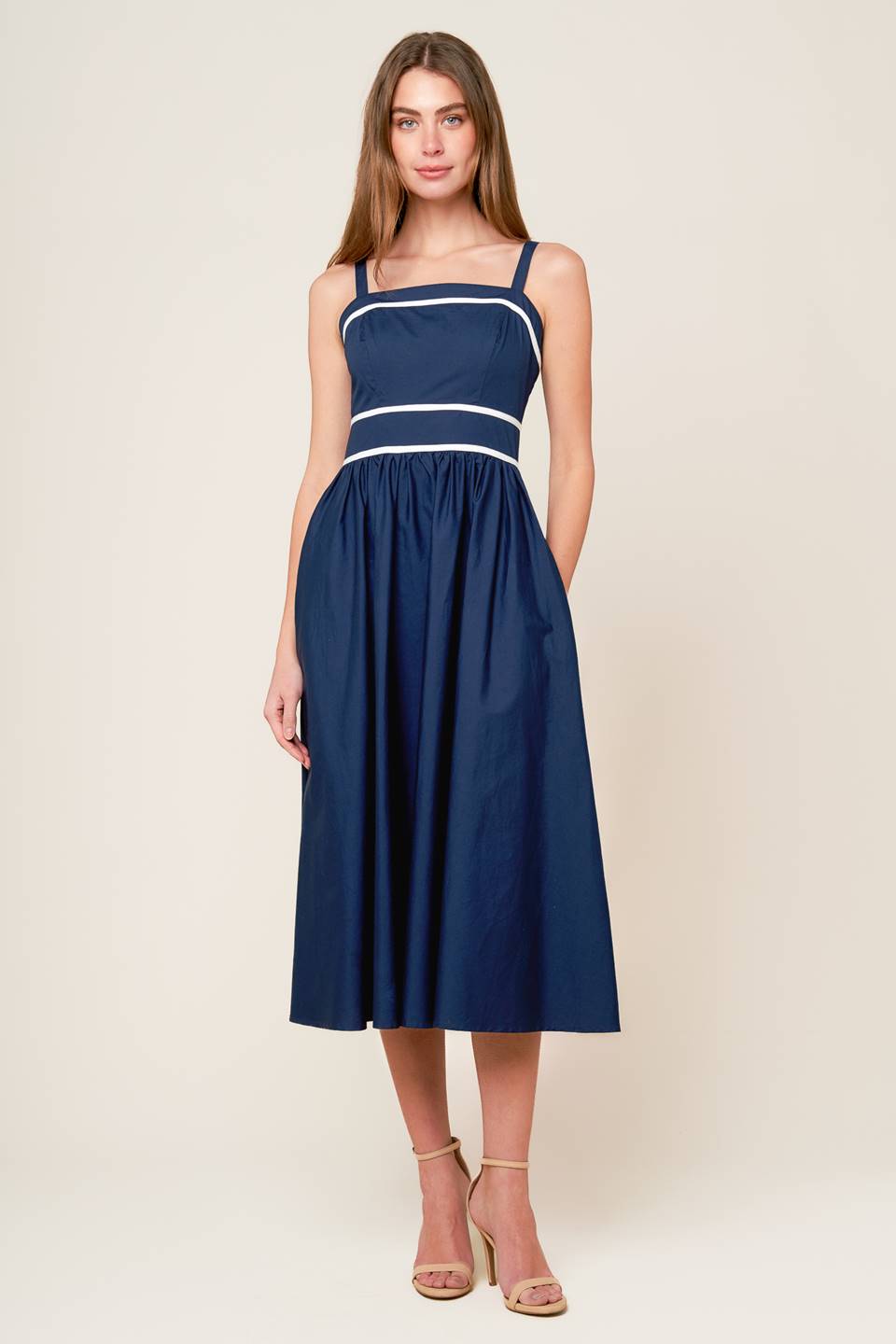 A solid navy woven midi dress featuring straight neckline, straps, full skirt and back zipper closure.