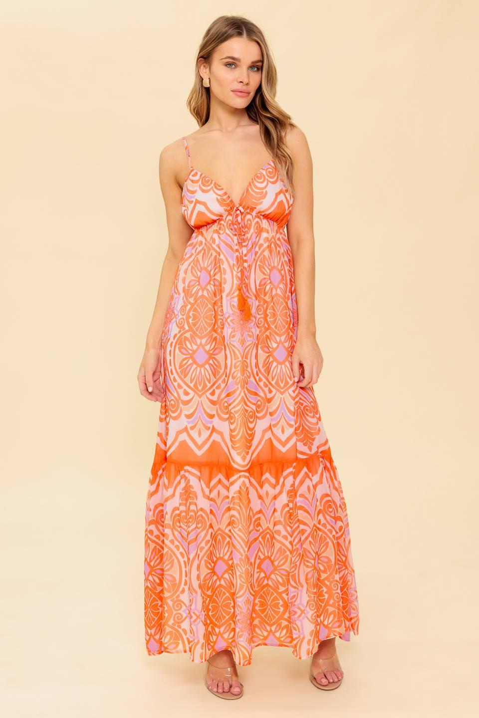 A printed woven maxi dress featuring cami top, elasticized empire with tie and ruffled hemline