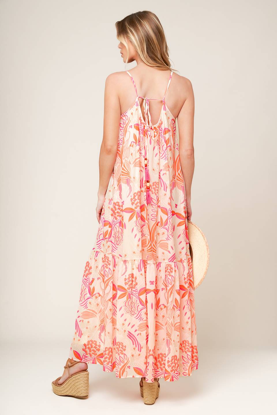 A printed woven maxi dress featuring cami dress featuring ruffled hemline and bare back with tie detail.