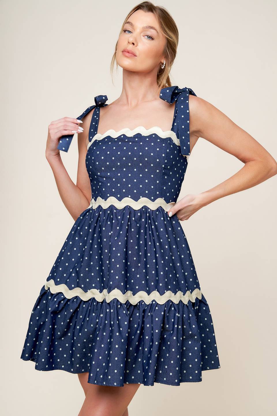 A dotted woven mini dress featuring straight neckline, ric rac ribbon detail, shoulder ties and smocked back bodice.