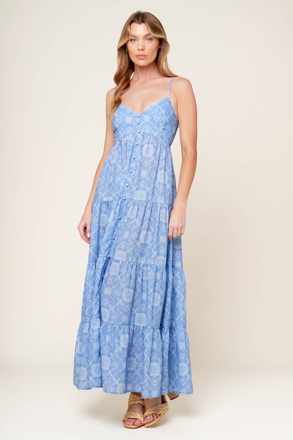 A blue printed woven maxi dress featuring cami top, straps, non-functional button down, tiered skirt, and smocked back bodice