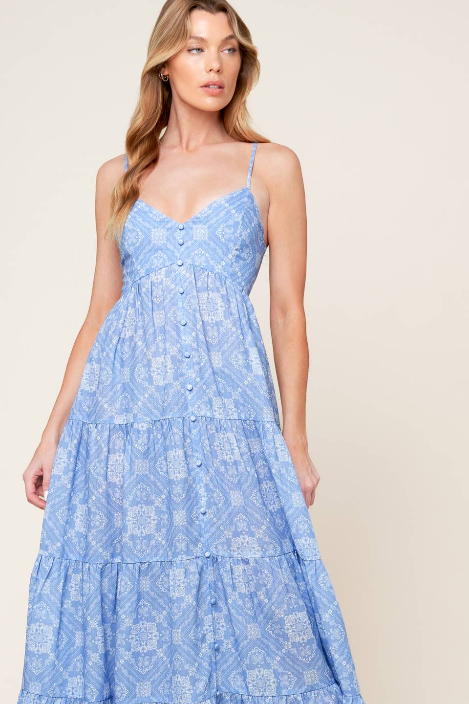 A blue printed woven maxi dress featuring cami top, straps, non-functional button down, tiered skirt, and smocked back bodice