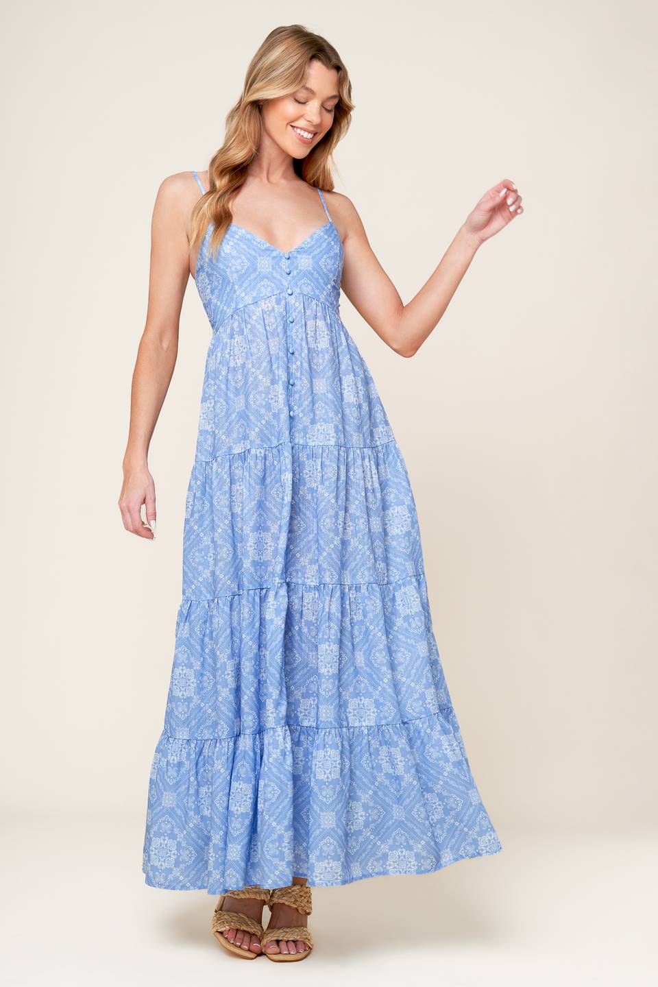 A blue printed woven maxi dress featuring cami top, straps, non-functional button down, tiered skirt, and smocked back bodice