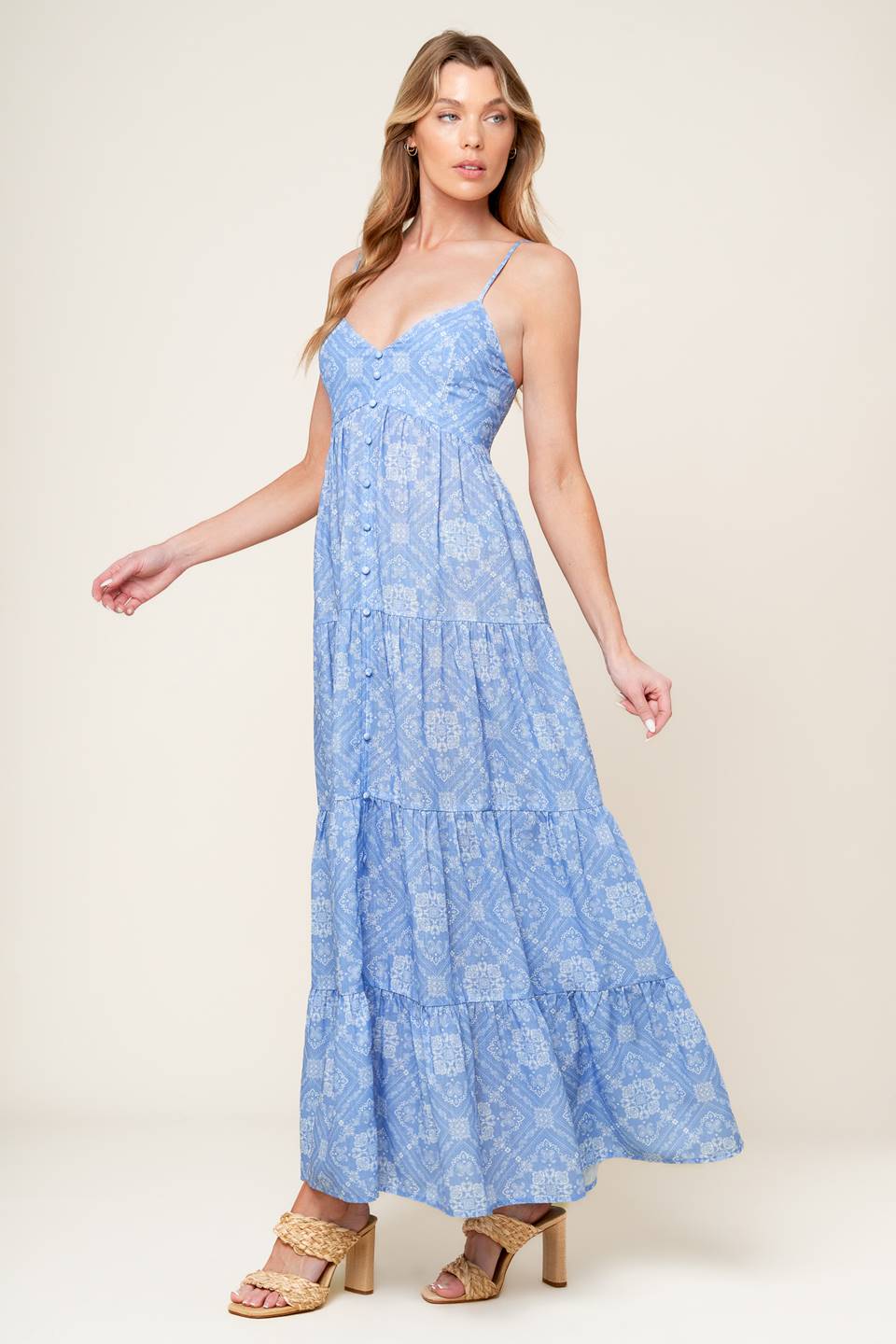 A blue printed woven maxi dress featuring cami top, straps, non-functional button down, tiered skirt, and smocked back bodice