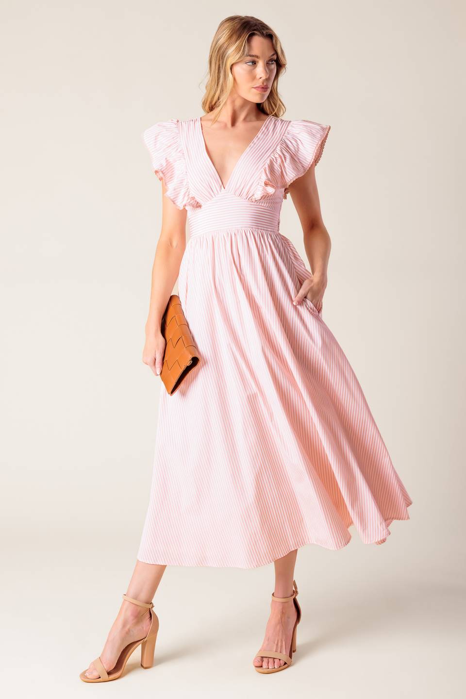 A pink and white striped woven midi dress featuring V neckline, ruffled sleeve, waist yoke, full skirt and bare back with tie detail.