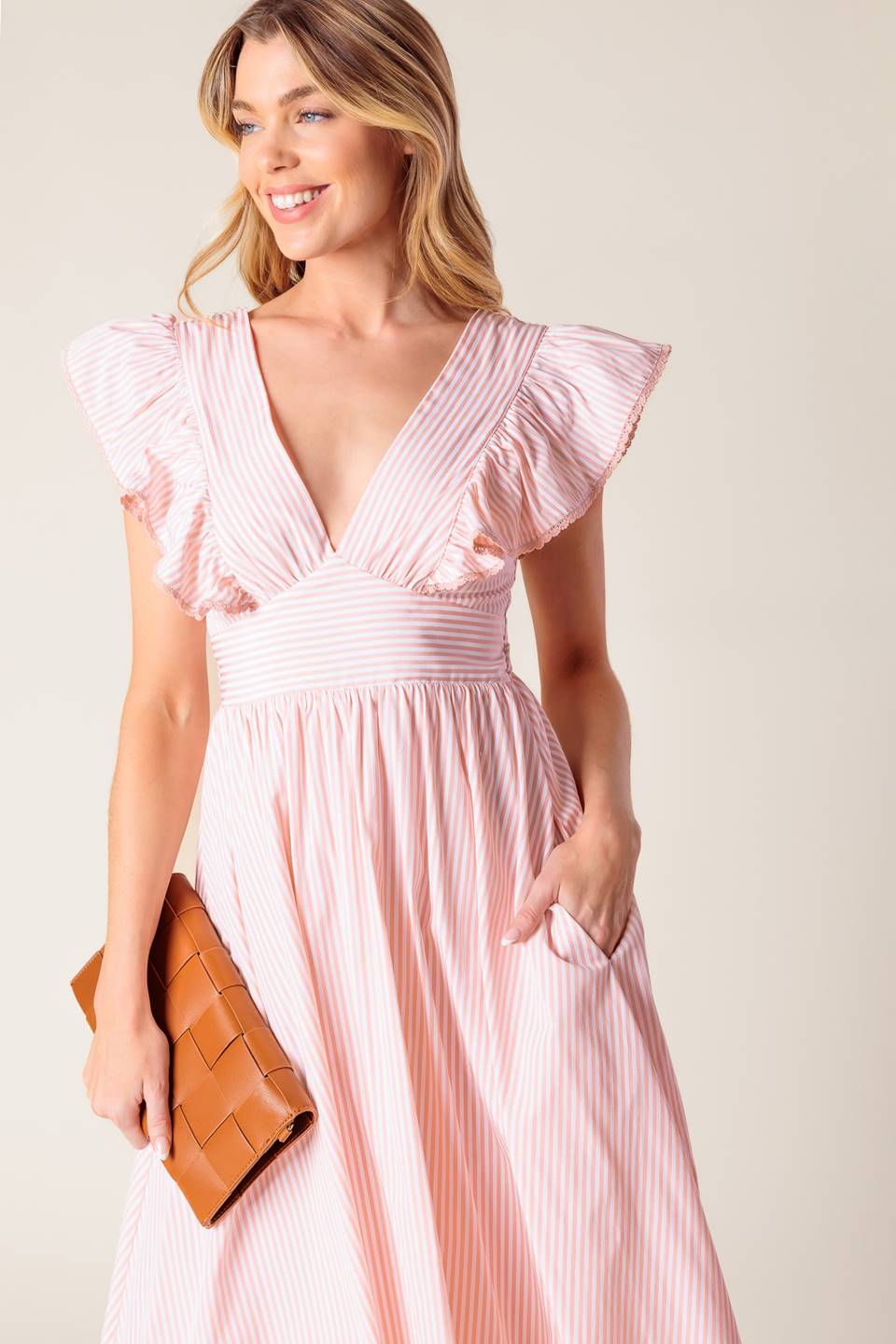 A pink and white striped woven midi dress featuring V neckline, ruffled sleeve, waist yoke, full skirt and bare back with tie detail.