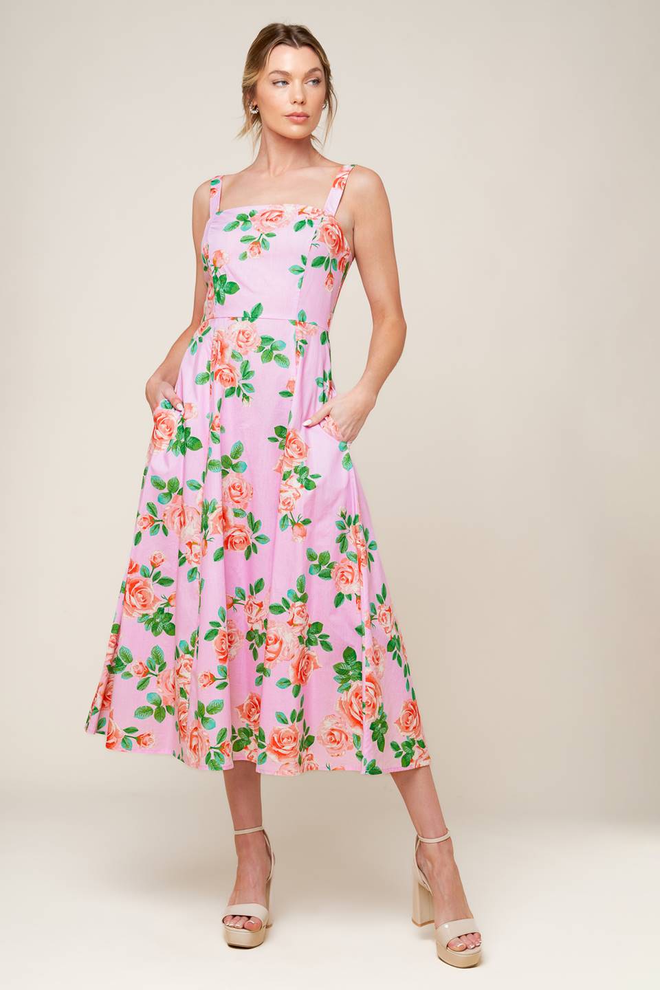 A pink floral printed woven midi dress featuring straight neckline, straps, circle skirt and back zipper closure.