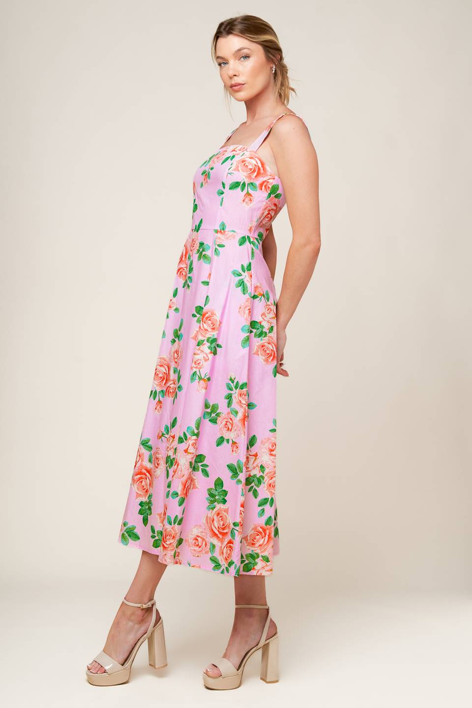 A pink floral printed woven midi dress featuring straight neckline, straps, circle skirt and back zipper closure.