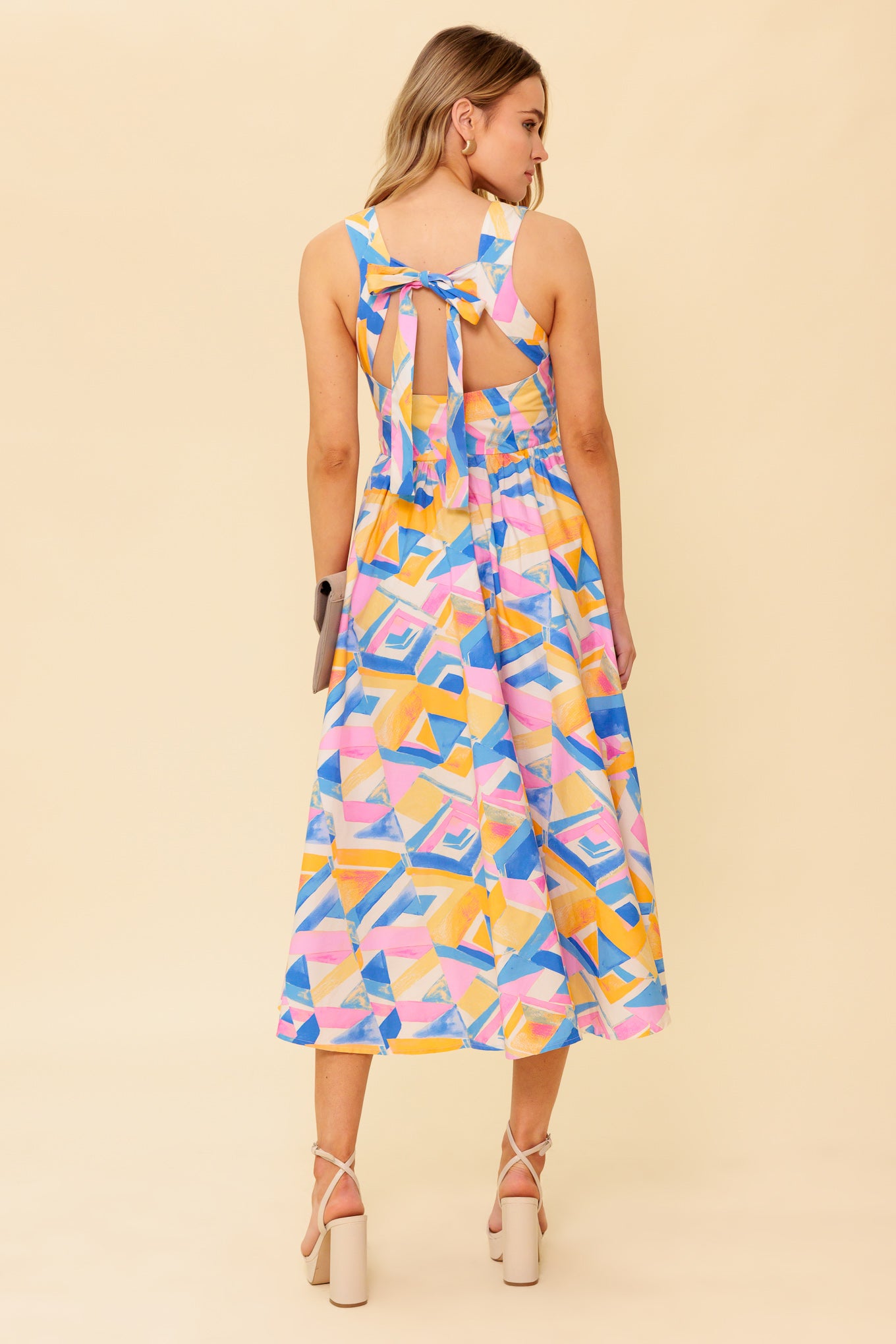 A printed woven midi dress featuring wide neckline, sleeveless, full skirt, bare back with tie and zipper closure