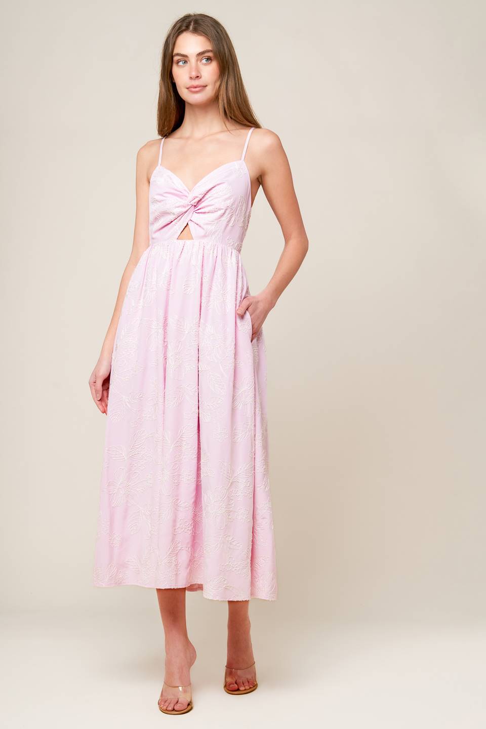 A pink textured woven midi dress featuring sweetheart neckline, front twist with cut out, straps and smocked back bodice.