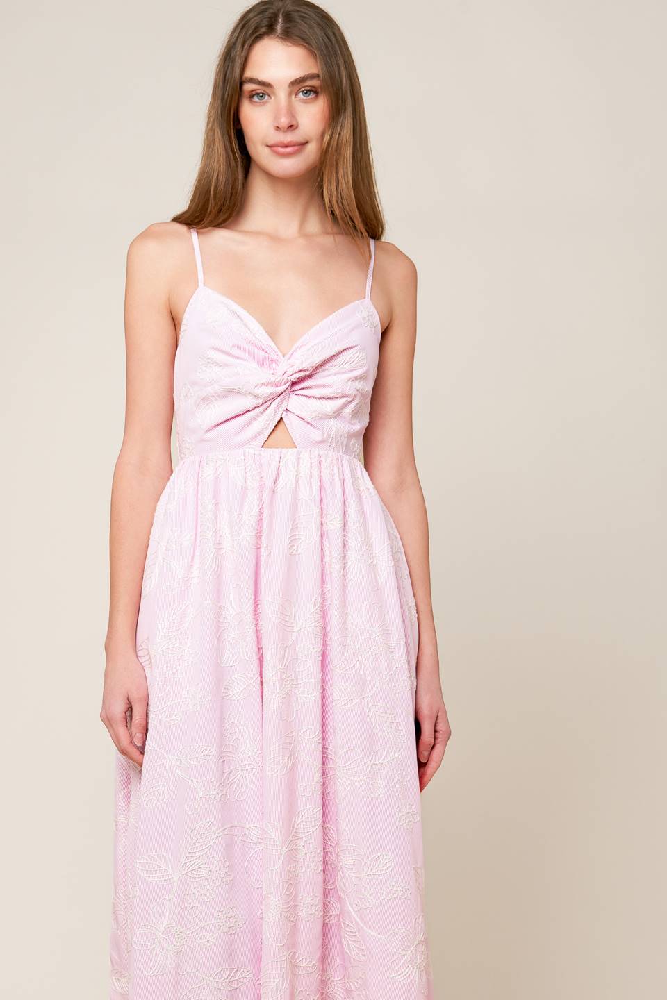 A pink textured woven midi dress featuring sweetheart neckline, front twist with cut out, straps and smocked back bodice.