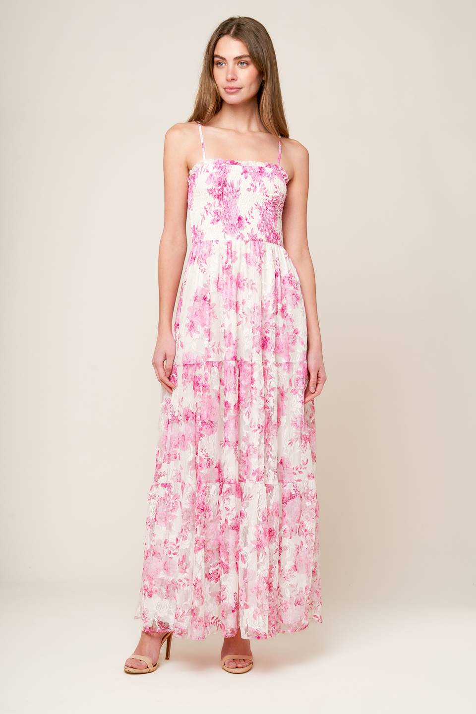 A pink and ivory, floral printed woven lace maxi dress featuring straight neckline with ruffled edge, straps, smocked bodice and tiered skirt.