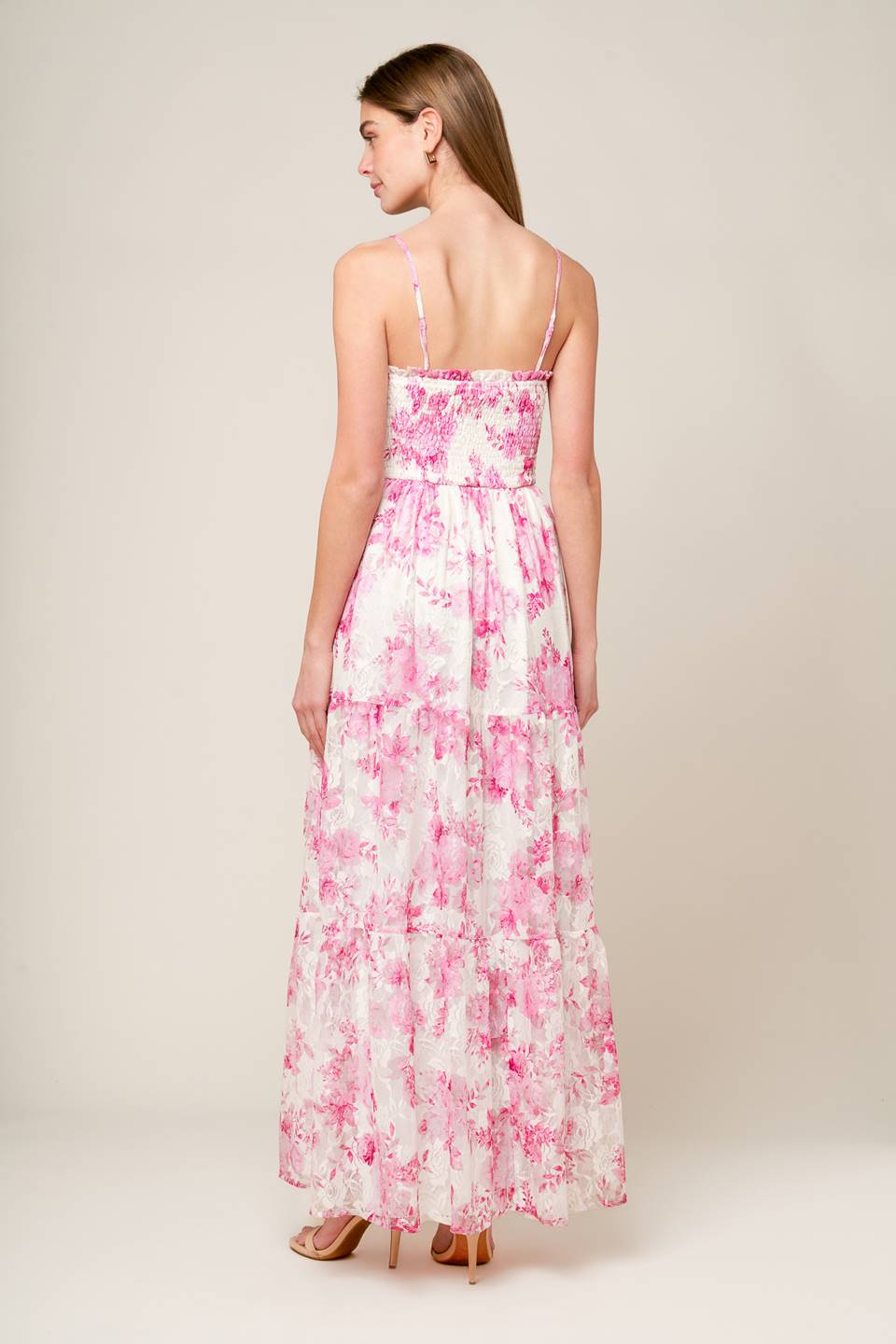 A pink and ivory, floral printed woven lace maxi dress featuring straight neckline with ruffled edge, straps, smocked bodice and tiered skirt.