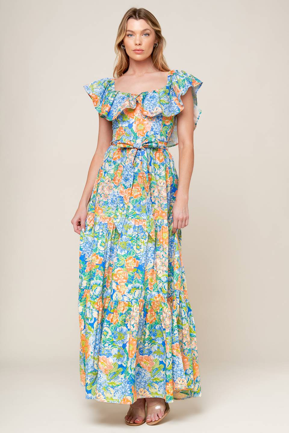 A printed woven maxi dress featuring off shoulder neckline, flounce, self sash tie, tiered skirt and smocked back bodice.