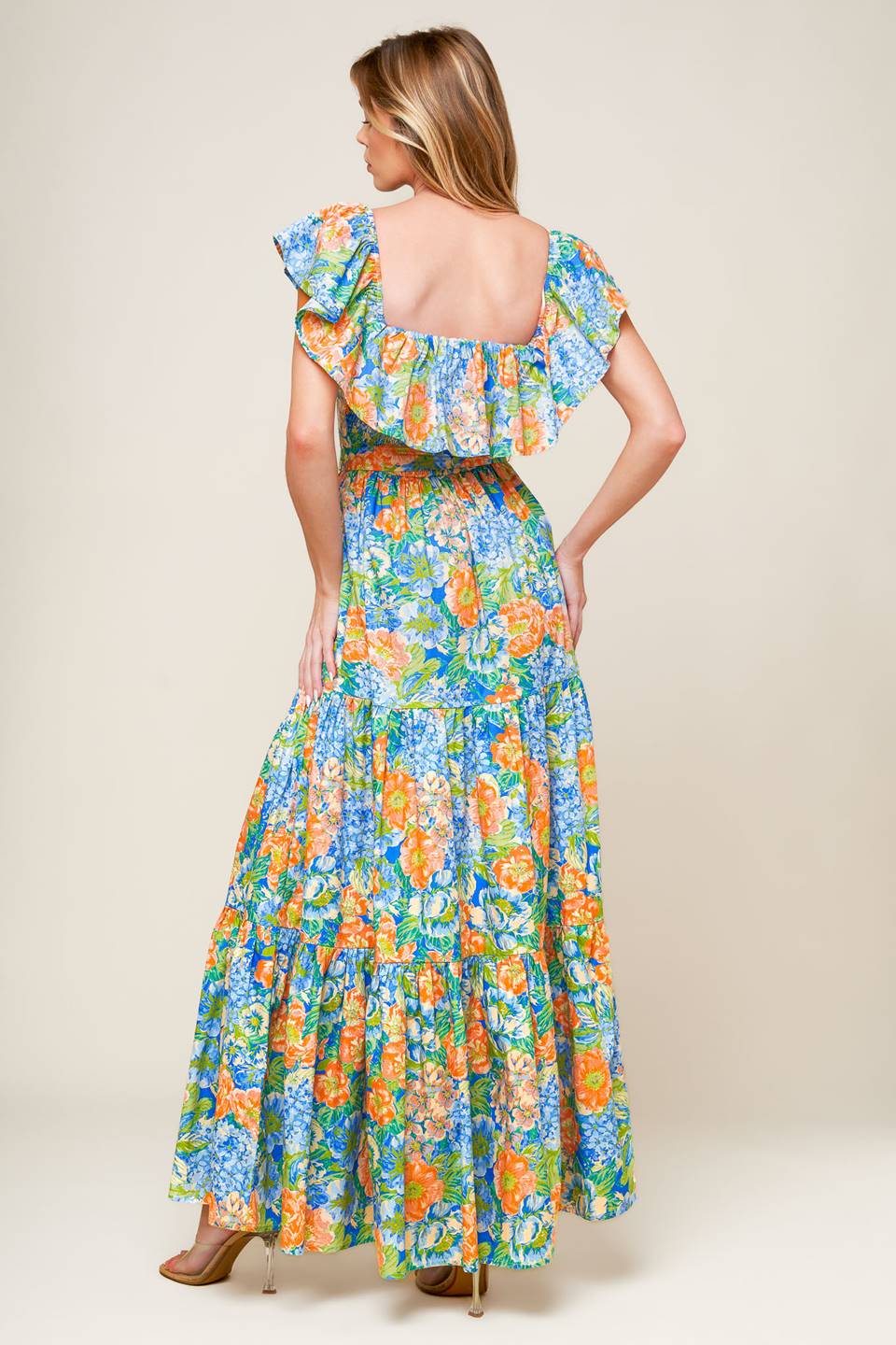 A printed woven maxi dress featuring off shoulder neckline, flounce, self sash tie, tiered skirt and smocked back bodice.