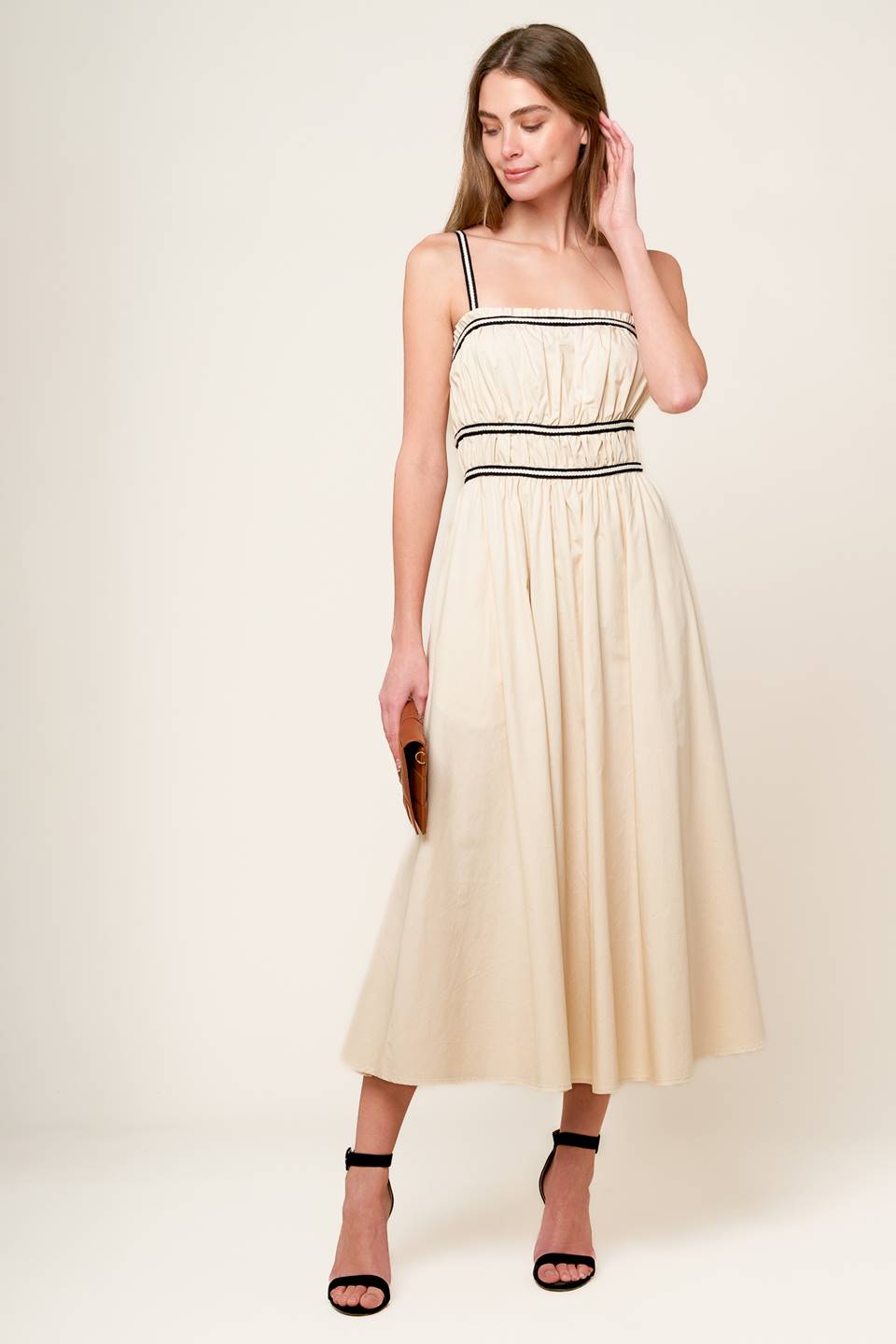 A solid woven midi dress featuring straight neckline with ruffled edge, contrasting strap and back zipper closure.