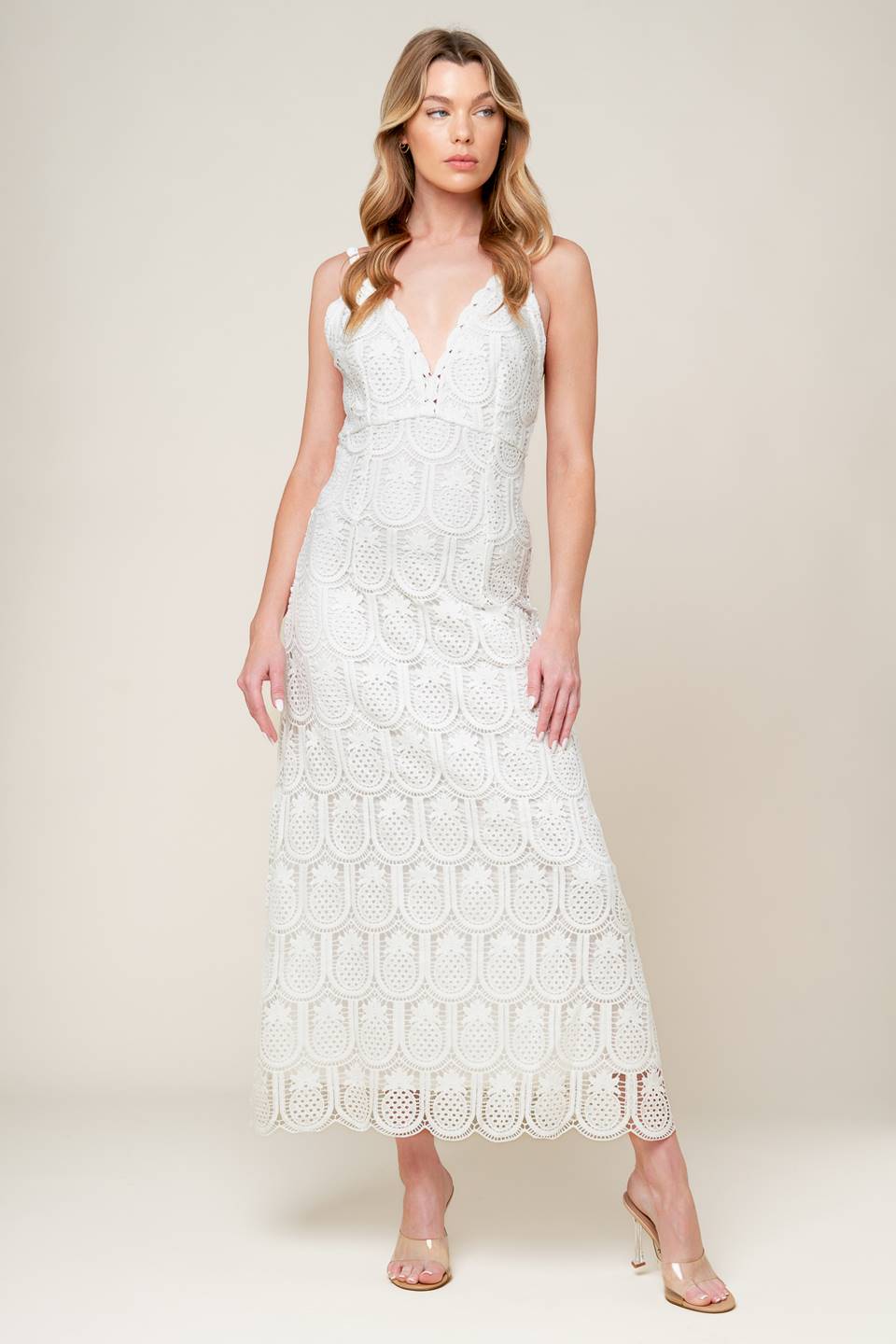 A white woven lace midi dress featuring lace trimmed V neckline and bare back with zipper closure.