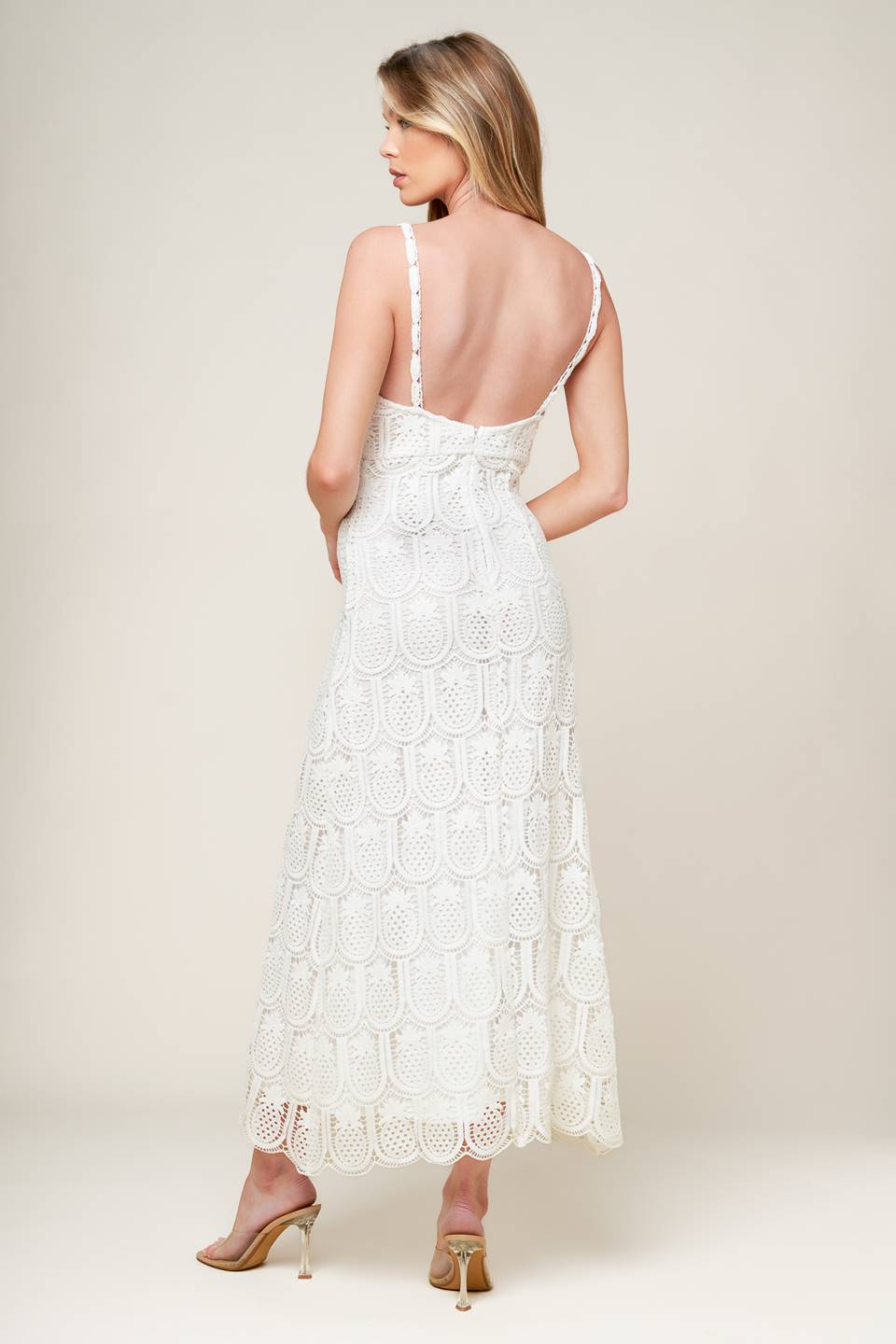 A white woven lace midi dress featuring lace trimmed V neckline and bare back with zipper closure.