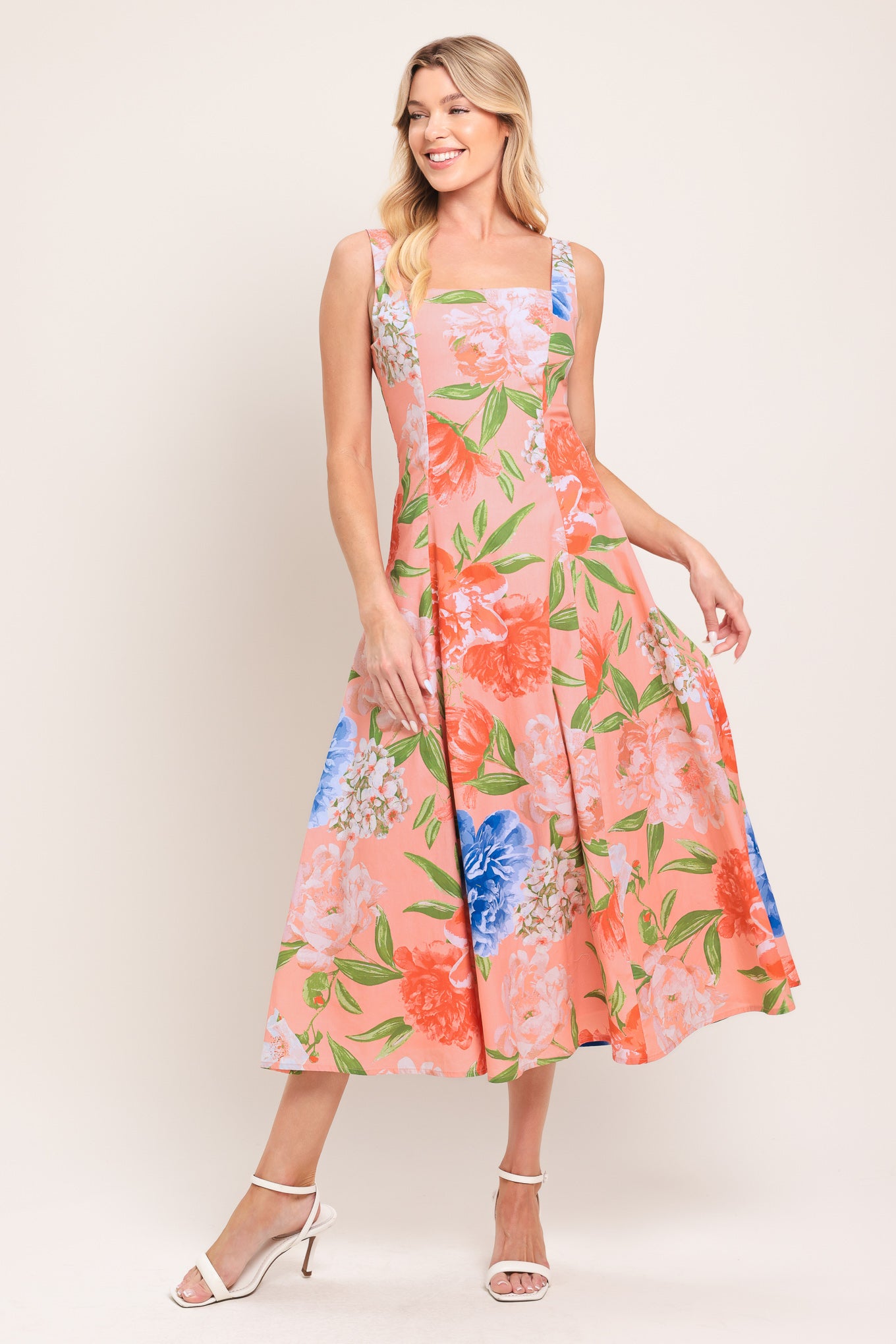 Woman wearing a sleeveless floral midi dress featuring square neckline, circle skirt and back zipper closure | Flying Tomato