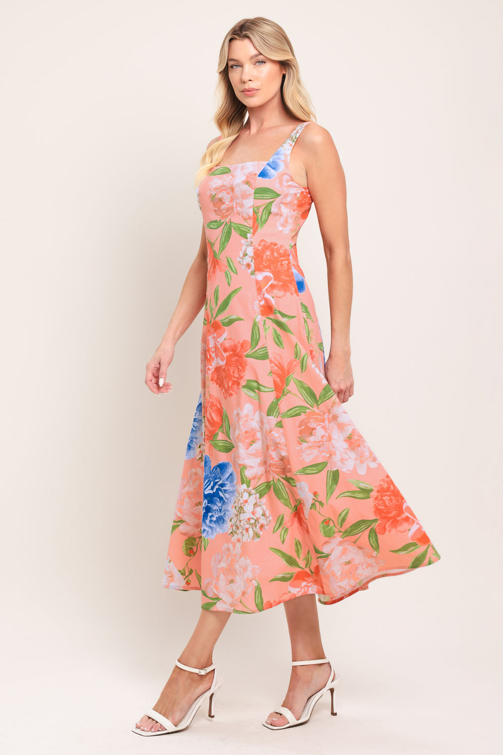 Woman wearing a sleeveless floral midi dress featuring square neckline, circle skirt and back zipper closure | Flying Tomato