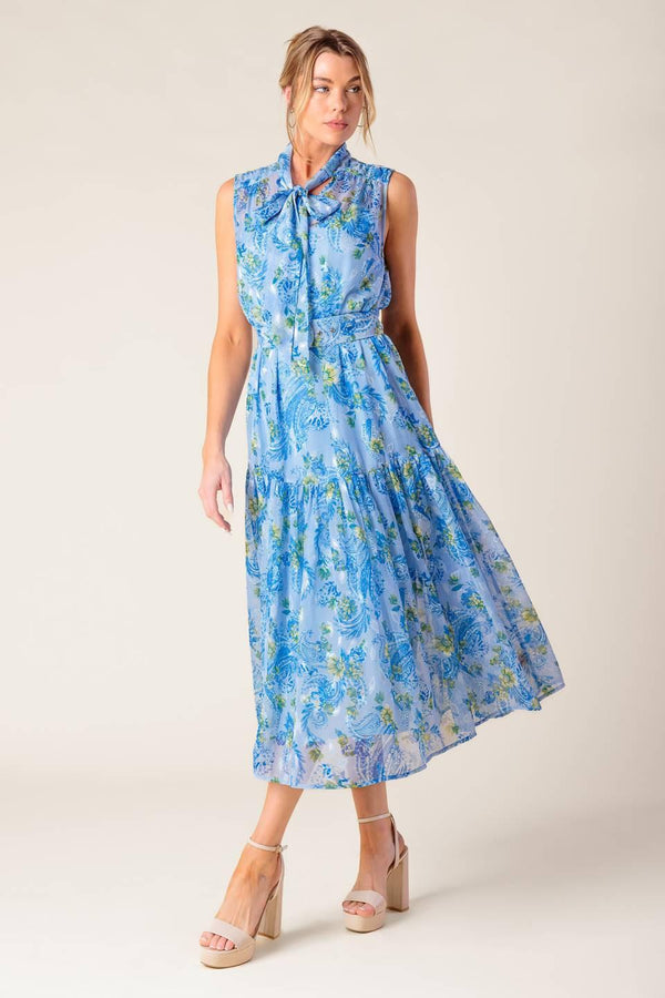 A printed woven midi dress featuring front bow tie, sleeveless, self belt and ruffled hemline