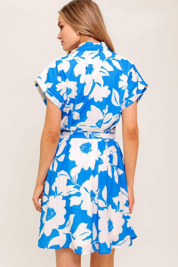 A printed woven mini dress featuring collar, button down, cuffed short sleeve and self sash tie.