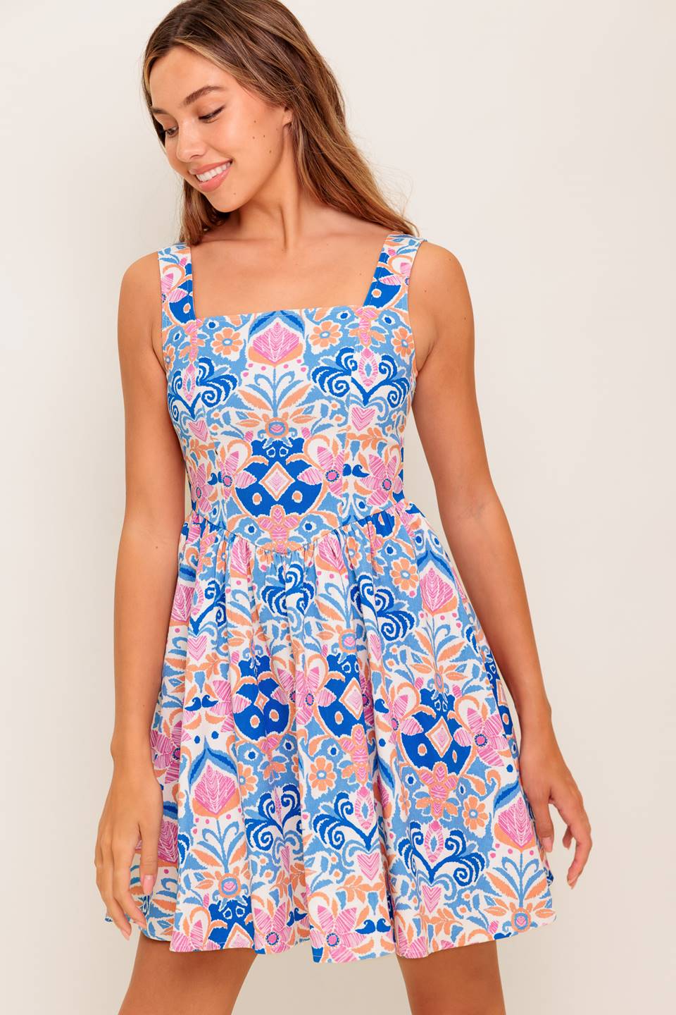 A printed woven mini dress featuring square neckline, sleeveless, basque waist, full skirt and back zipper closure