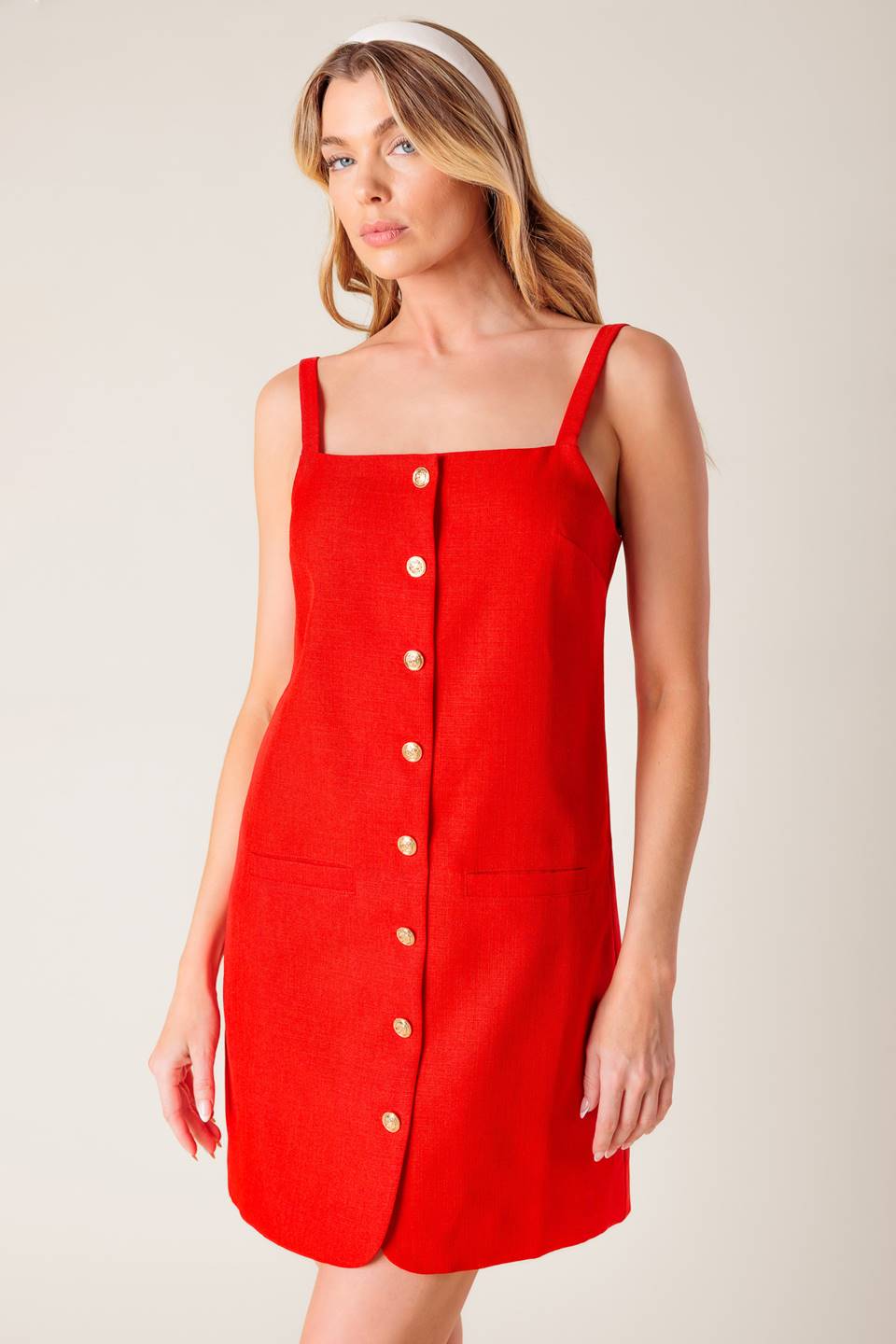 A solid red woven shift dress with front button closure.