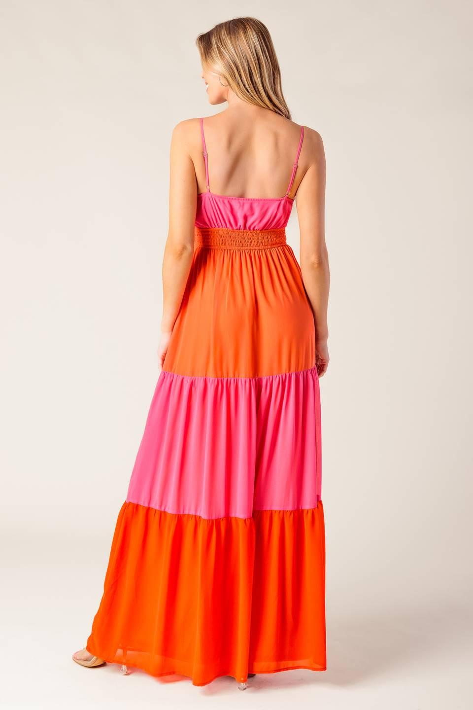 A solid woven color blocked maxi dress featuring cami top with straps, shirred waist band with center hardware, tiered skirt and smocked back waistband