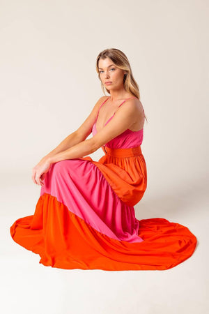 A solid woven color blocked maxi dress featuring cami top with straps, shirred waist band with center hardware, tiered skirt and smocked back waistband