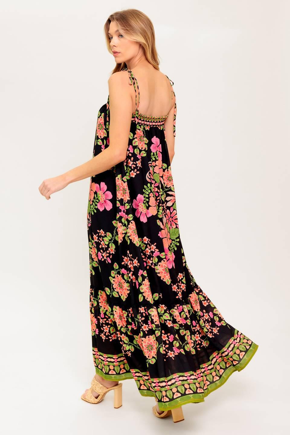 A printed woven maxi dress featuring straight neckline, shoulder tie and ruffled hem