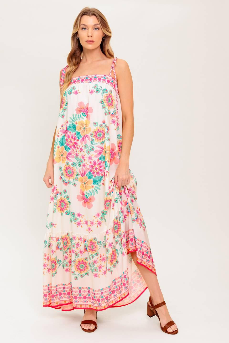 A printed woven maxi dress featuring straight neckline, shoulder tie and ruffled hem