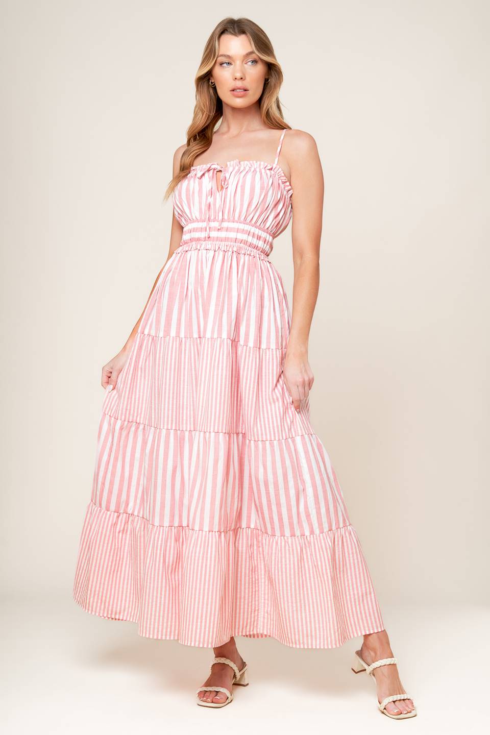 A striped woven maxi dress featuring a straight neckline with ruffled edge and front tie, elasticized waist and tiered skirt.