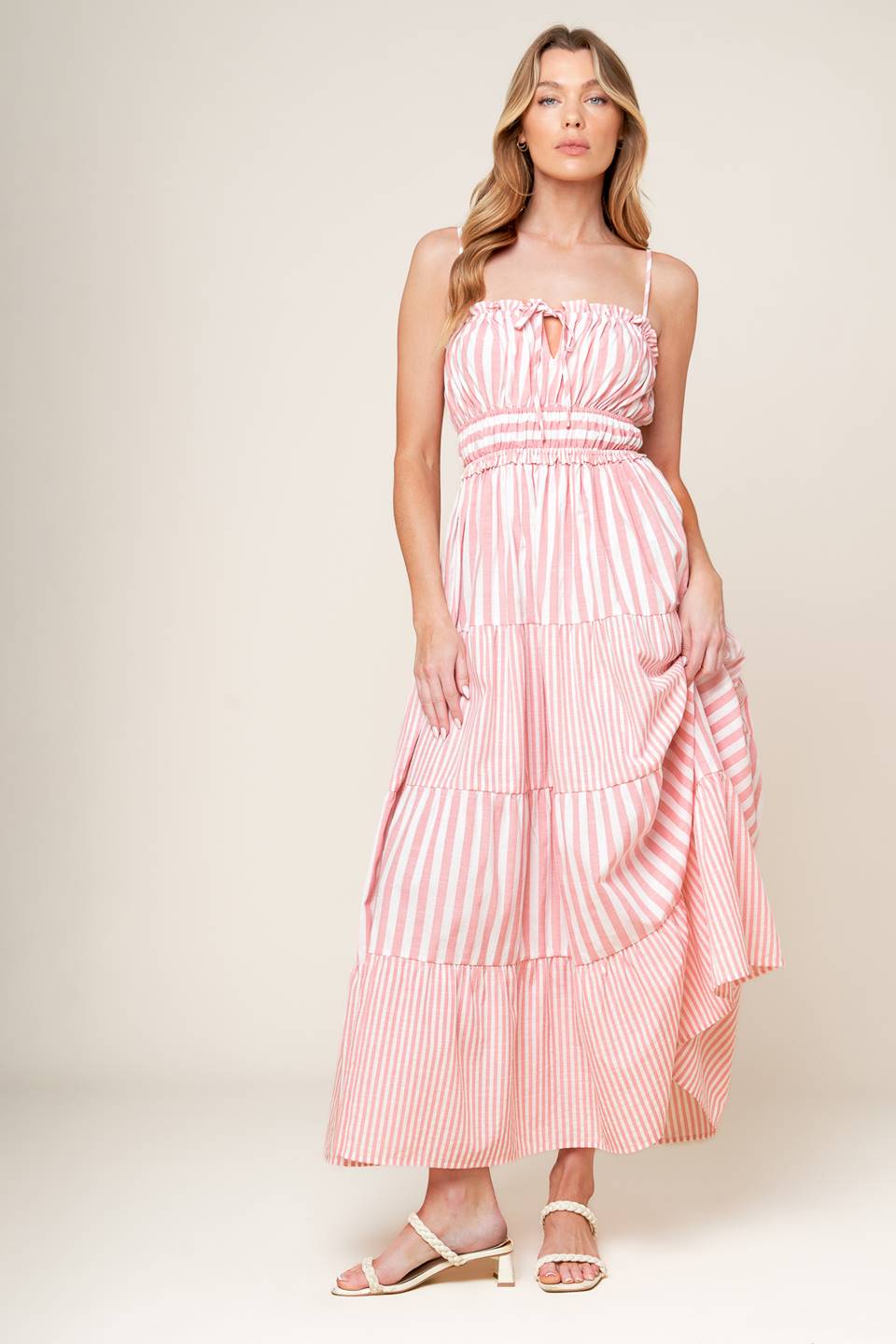 A striped woven maxi dress featuring a straight neckline with ruffled edge and front tie, elasticized waist and tiered skirt.