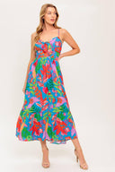 A printed woven dress featuring cami bodice with front tie detail, straps, ruffled hem and smocked back waist band