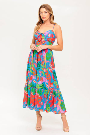 A printed woven dress featuring cami bodice with front tie detail, straps, ruffled hem and smocked back waist band