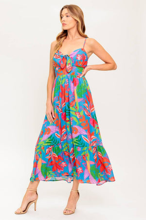 A printed woven dress featuring cami bodice with front tie detail, straps, ruffled hem and smocked back waist band