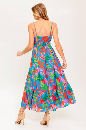 A printed woven dress featuring cami bodice with front tie detail, straps, ruffled hem and smocked back waist band