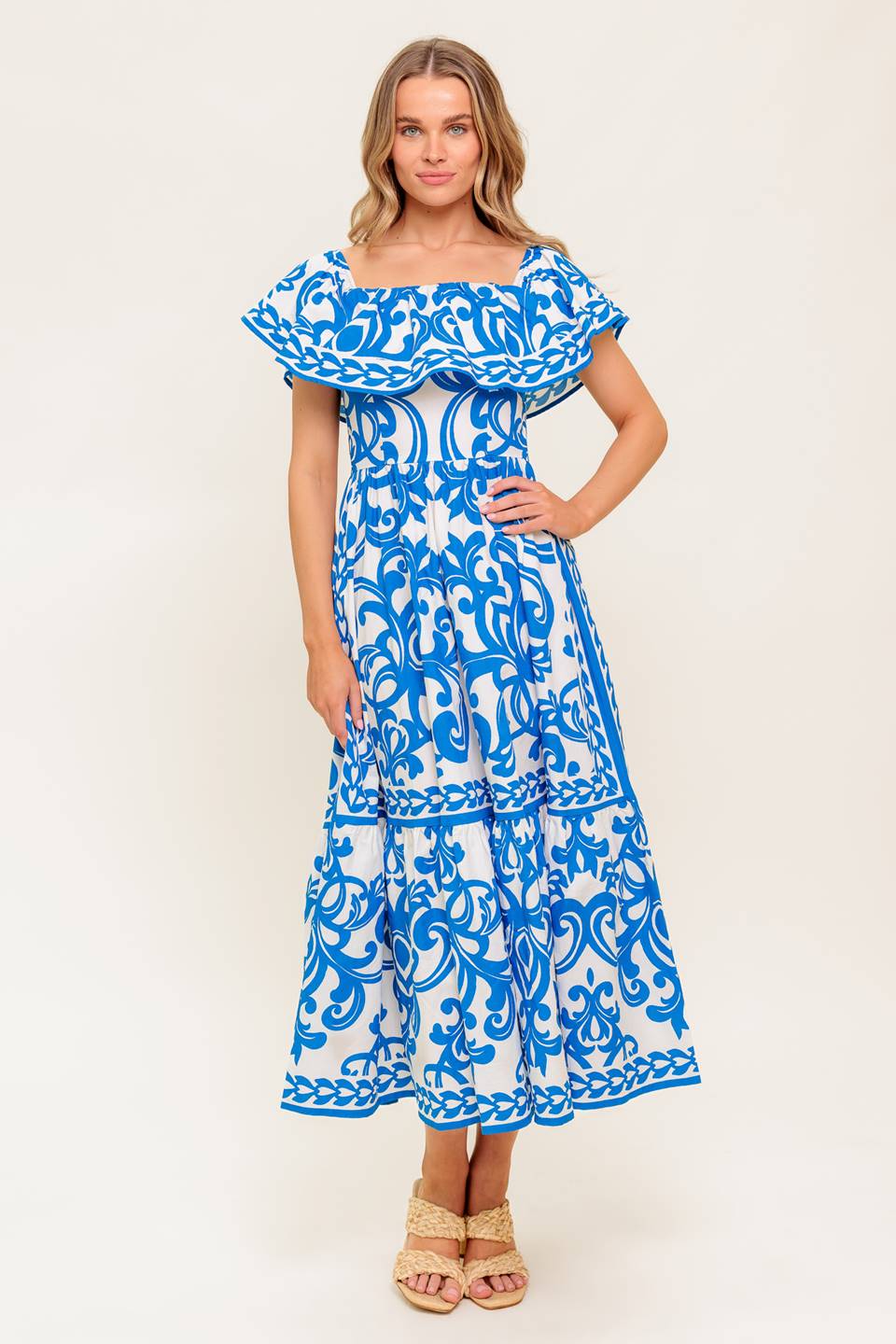 A printed woven midi dress featuring off shoulder neckline with flounce, ruffled hem and back zipper closure