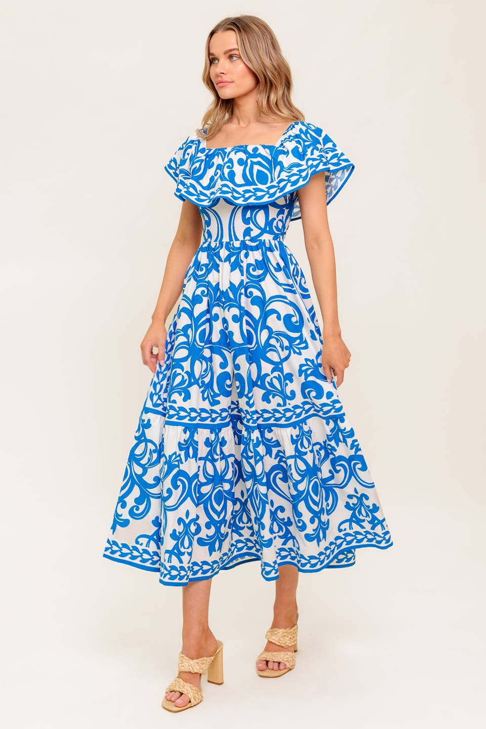 A printed woven midi dress featuring off shoulder neckline with flounce, ruffled hem and back zipper closure