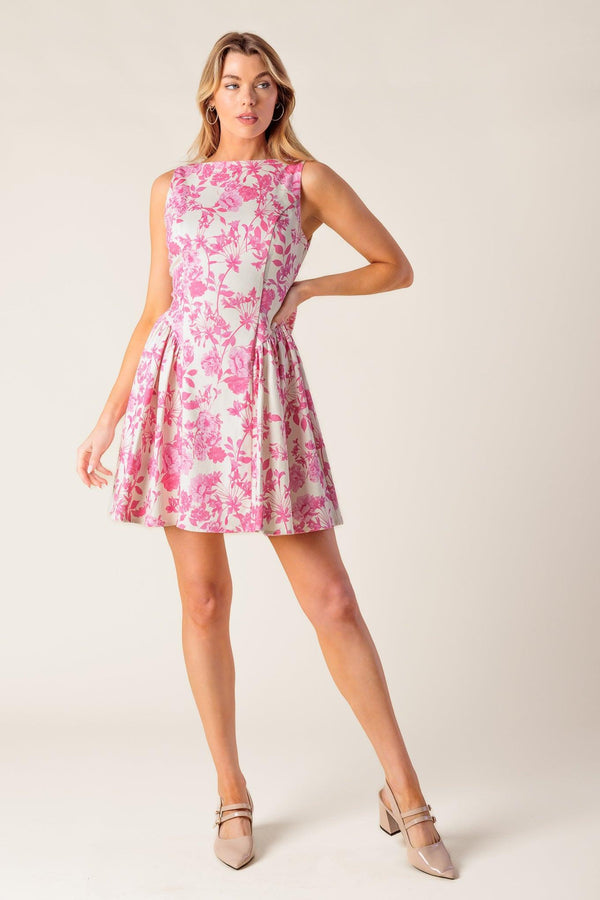 A printed woven mini dress featuring boat neckline, sleeveless, shirred side panel, bare back with bow detail and side zipper closure