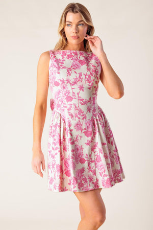 A printed woven mini dress featuring boat neckline, sleeveless, shirred side panel, bare back with bow detail and side zipper closure