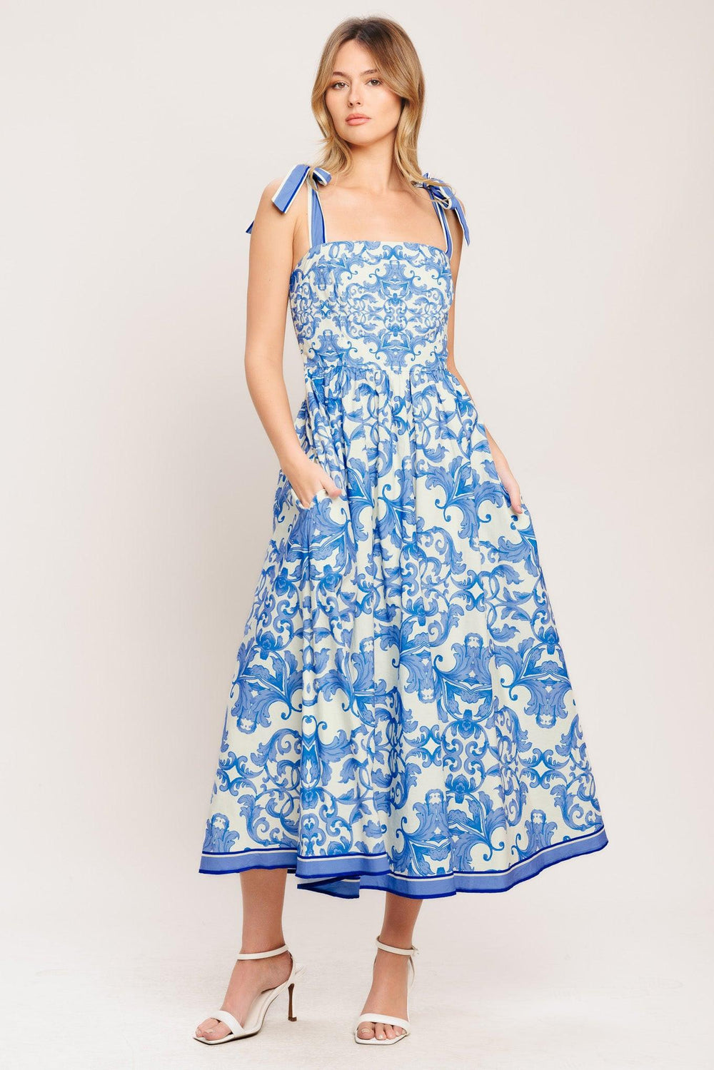 A printed woven midi dress featuring straight neckline, shoulder ties, full skirt and smocked back bodice

Details:

Self: 100% Cotton

Lining: 100% Polyester

Size & Fit

-Model is 5`8" And Wearing Size Small
-Measurements Taken From Size Small
-Approx. Length: 52"