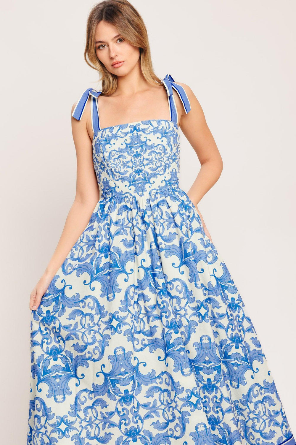 A printed woven midi dress featuring straight neckline, shoulder ties, full skirt and smocked back bodice

Details:

Self: 100% Cotton

Lining: 100% Polyester

Size & Fit

-Model is 5`8" And Wearing Size Small
-Measurements Taken From Size Small
-Approx. Length: 52"