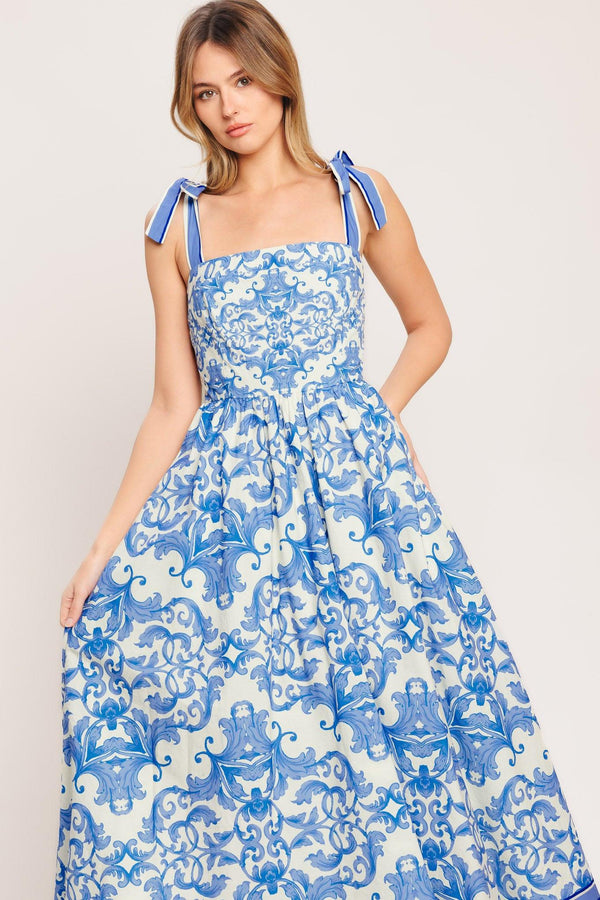 A printed woven midi dress featuring straight neckline, shoulder ties, full skirt and smocked back bodice

Details:

Self: 100% Cotton

Lining: 100% Polyester

Size & Fit

-Model is 5`8" And Wearing Size Small
-Measurements Taken From Size Small
-Approx. Length: 52"