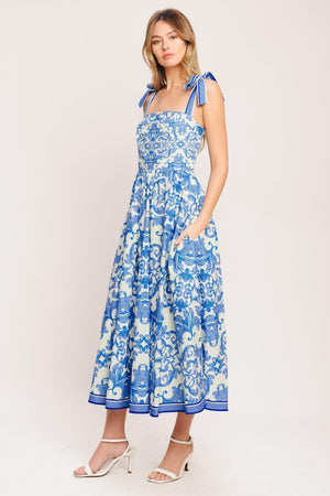A printed woven midi dress featuring straight neckline, shoulder ties, full skirt and smocked back bodice

Details:

Self: 100% Cotton

Lining: 100% Polyester

Size & Fit

-Model is 5`8" And Wearing Size Small
-Measurements Taken From Size Small
-Approx. Length: 52"