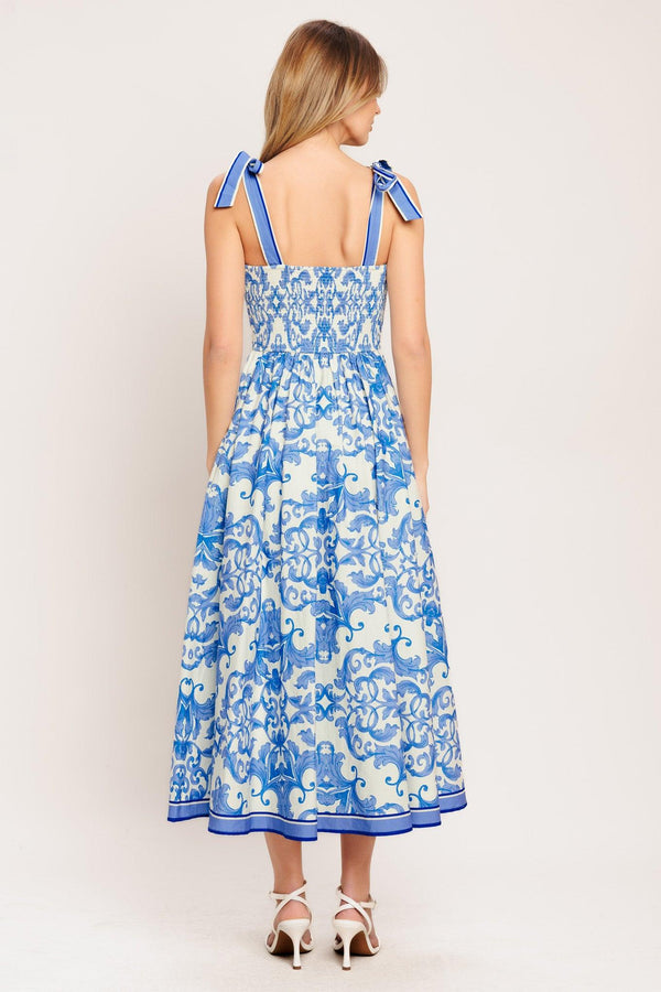 A printed woven midi dress featuring straight neckline, shoulder ties, full skirt and smocked back bodice

Details:

Self: 100% Cotton

Lining: 100% Polyester

Size & Fit

-Model is 5`8" And Wearing Size Small
-Measurements Taken From Size Small
-Approx. Length: 52"