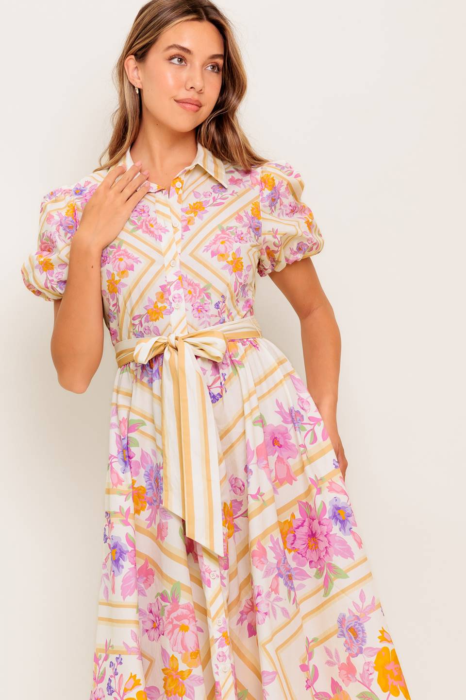 A printed woven midi dress featuring collar, short sleeve, button down, self sash belt and full skirt