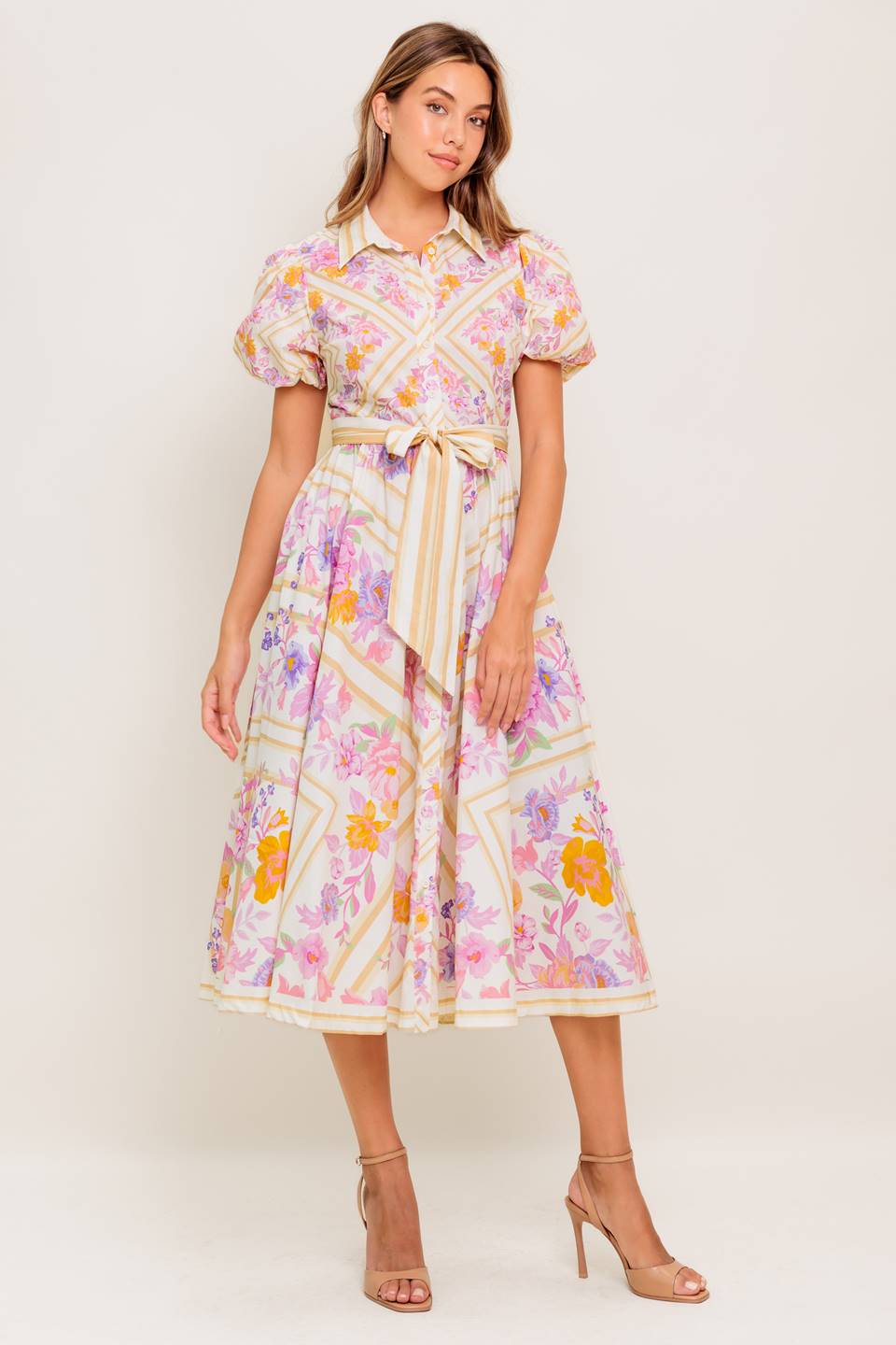 A printed woven midi dress featuring collar, short sleeve, button down, self sash belt and full skirt