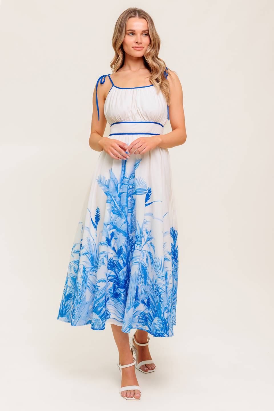 A printed woven midi dress featuring straight neckline, shoulder ties, full skirt and smocked back waistband.